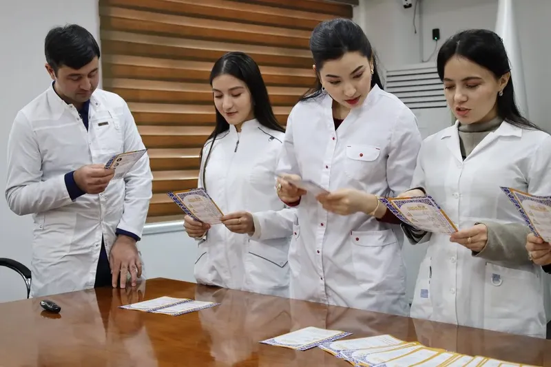 Students in white coats reading leaflets at Career Day